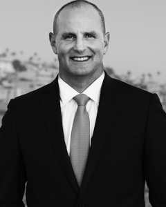 Black and white headshot of Steve Columbaro wearing a suit and tie