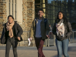 Three students walking through the plaza