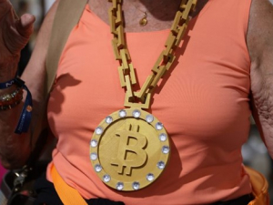 Large bitcoin necklace being worn by woman