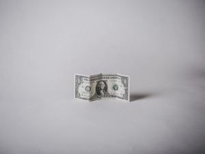 A dollar bill on a grey background