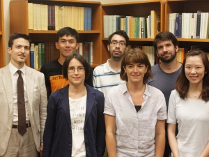 6 scholars in front of a bookshelf