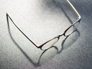 eyeglasses with white frames on grey table