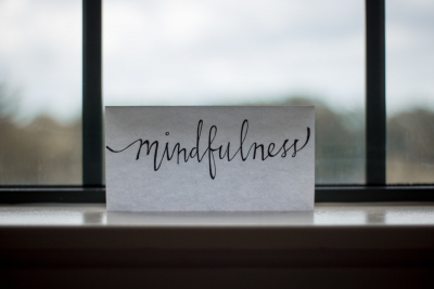 A sign in front of a window that reads "mindfulness"