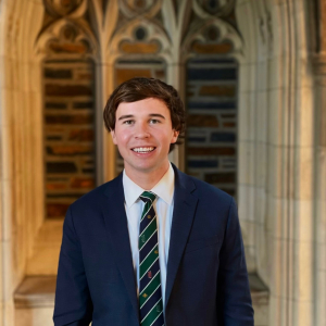 Portrait photo of Connor Booher with Duke Chapel arch in the background